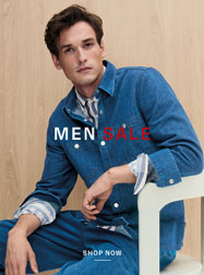 MEN SALE: Mann im Denim‑Look vor Holzstruktur, mit rotem ‚SALE‘ Schriftzug inszeniert – moderne Premium‑Herrenmode.