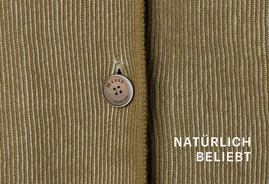 Detailaufnahme eines strukturierten Baumwoll Stricks in warmem Ton, hochwertig verarbeitet für natürliche, langlebige Premium Qualität.