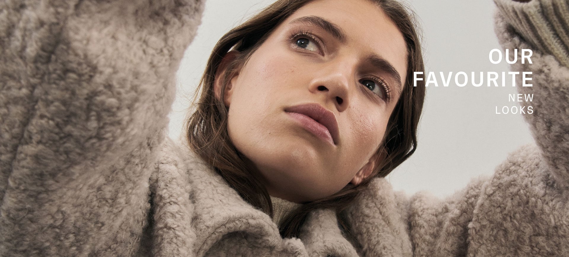 Favourite New Look Eine Frau in lässiger Pose trägt eine beige Teddyjacke. Text: Favourite New Look