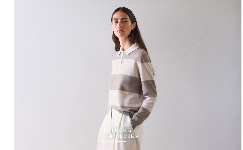 Look 5 entdecken: Frau im gestreiften Strick Polo in soften Naturtönen und weiter Hose, modern und ruhig inszeniert für eine edle Premium Ästhetik.