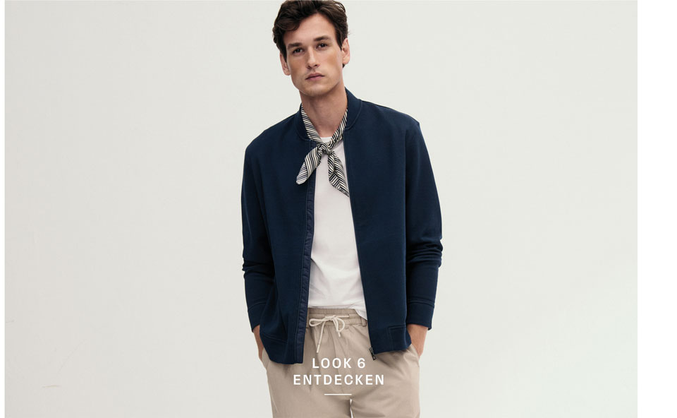 Look 6 Entdecken: Mann in navyfarbener Strickjacke über Shirt und Denim Hemd, modern kombiniert – elegante Premium Knitwear für vielseitige Herrenlooks.