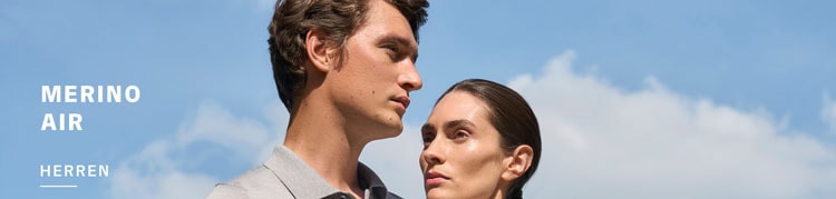 Mann und Frau in leichten Merino Air Looks, modern vor blauem Himmel inszeniert – extrafeiner Strick für luftige Premium Ästhetik.
