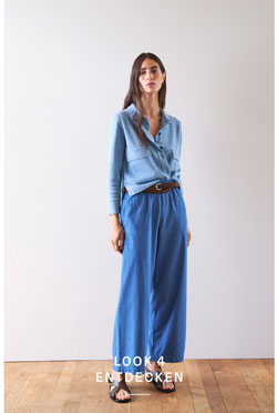 Look 4 entdecken: Frau im hellblauen Strickhemd und weiter Hose, modern und lässig kombiniert – leichter, hochwertiger Knit Denim für zeitlose Premium Ästhetik.