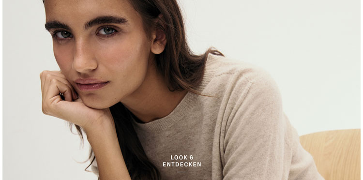 Look 6 entdecken: Frau in weichem Feinstrick Pullover in warmem Beige, minimalistisch inszeniert für eine natürliche, hochwertige Premium Note.