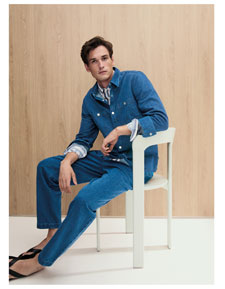 Mann im kompletten Knitted Denim Set aus Jacke und Hose, lässig kombiniert mit Hemd – strukturierte Premium Knitwear in ikonischem Blau.