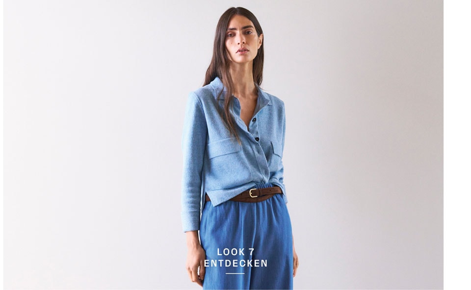Look 7 entdecken: Our Favourite New Looks. Frau im hellblauen Strickhemd und weiter Hose, modern und lässig kombiniert – leichter, hochwertiger Knit Denim für zeitlose Premium Ästhetik.