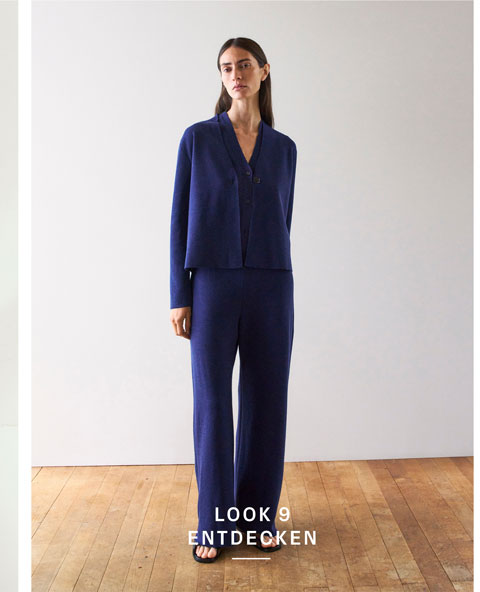 Look 9 entdecken: Our Favourite New Looks. Frau im dunkelblauen Strickset aus Cardigan und Hose, minimalistisch inszeniert für eine ruhige, hochwertige Premium Ästhetik.