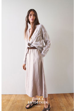 Look 1 entdecken: Our Favourite New Looks. Frau in heller Strickjacke mit grafischen Muster und langem Rock, locker gestylt mit Gürtel und Sandalen, ruhig im Studio inszeniert.