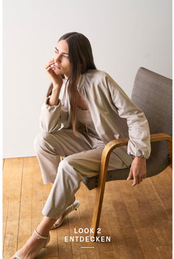 Look 2 entdecken: Our Favourite New Looks. Frau in heller Strickjacke mit passender Hose, entspannt im Licht eines modernen Wohnraums inszeniert.