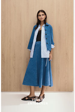 Look 8 entdecken: Our Favourite New Looks. Frau im modernen Knitted Denim Set aus Jacke, Hemd und Rock – strukturierter Baumwollstrick für zeitlose Premium Eleganz.