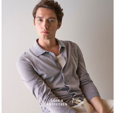 Look 4 entdecken: Our Favourite New Looks. Mann in feiner Strickjacke und heller Hosen, lässig im modernen Indoor Setting präsentiert.