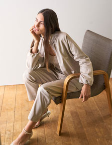 Our Favourite New Looks: Frau in heller Strickjacke mit passender Hose, entspannt im Licht eines modernen Wohnraums inszeniert.