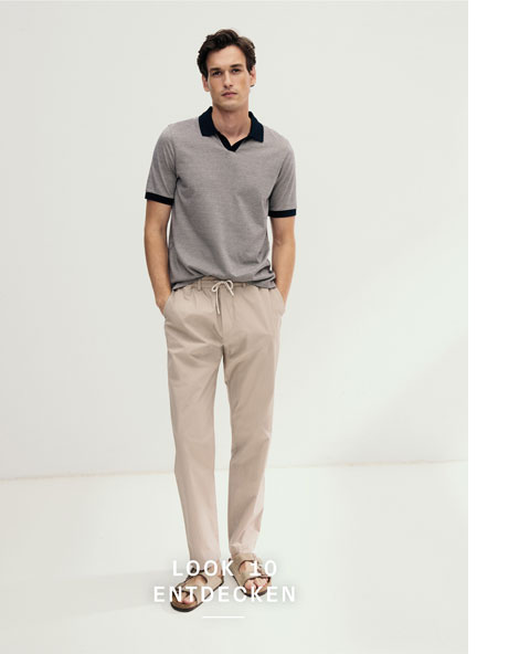 Look 10 entdecken: Our Favourite New Looks. Mann im modernen Strickpolo mit dunklem Kragen und heller Hose, clean im Studio präsentiert – ein smarter Premium Everyday Look.