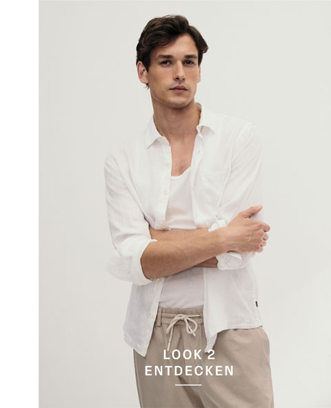 Look 2 entdecken: Our Favourite New Looks: Mann im weißen Shirt und offenem Hemd, kombiniert mit beigefarbener Hose, modern im hellen Studio inszeniert.