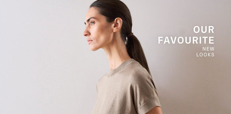 Our Favourite New Looks: Frau im soften, beigefarbenen Stricktop, seitlich vor heller Wand inszeniert – moderner, reduzierter Spring‑Summer Look.