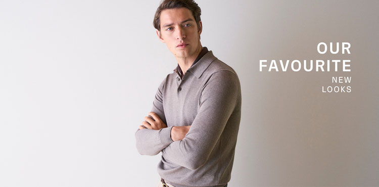 Our Favourite New Looks: Mann im feinen, beigefarbenen Strickpolo, seitlich vor heller Wand inszeniert – moderner, reduzierter Spring‑Summer Look.