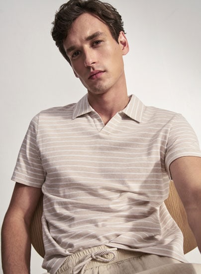 Our Favourite New Looks: Mann im gestreiften Strickpolo und heller Hose, klar im Studio präsentiert – zeitloser Everyday Look zum Nachstylen.