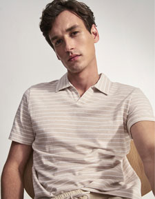 Our Favourite New Looks: Mann im gestreiften Strickpolo und heller Hose, klar im Studio präsentiert – zeitloser Everyday Look zum Nachstylen.