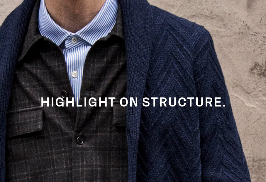 CRAFTED MERINOS: Detailansicht eines strukturierten Stricklooks aus 100 % Merino extrafine mit Hemd und Overshirt, präsentiert mit Fokus auf markante Strickstrukturen.