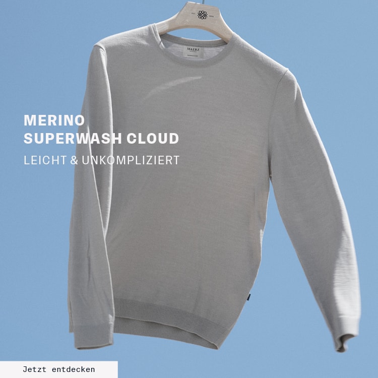 MERINO SUPERWASH CLOUD: Leichter Merino‑Strickpullover vor blauem Hintergrund präsentiert, pflegeleichte Premium‑Qualität aus extrafeiner Merinowolle mit dem Call‑to‑Action ‚Jetzt entdecken‘.
