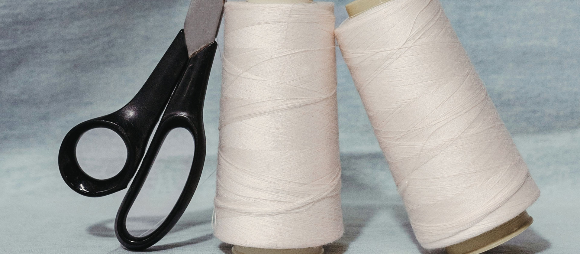 Feine Spulen aus Cotton‑und‑Linen‑Garn, ruhig und hochwertig inszeniert – natürliche Materialien für moderne Premium‑Sommerlooks.