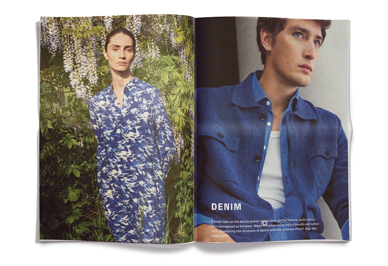 Mann im floralen Denim‑Look, vor üppiger Natur inszeniert – moderner Premium‑Sommerstil.