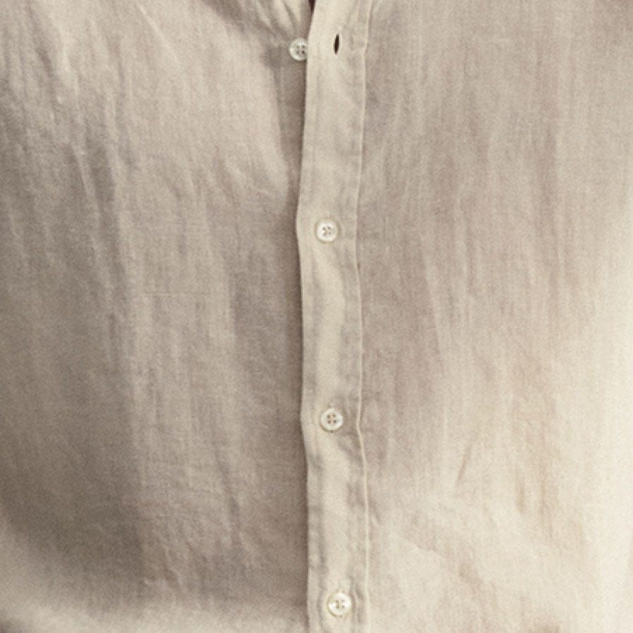 Detailaufnahme eines natürlichen Linen‑Stoffs, leicht strukturiert und hochwertig verarbeitet für sommerliche Premium‑Looks.