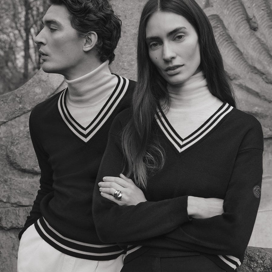 Mann und Frau im sportlich-klassischen Retro-Stricklook mit entspannter Körperhaltung.