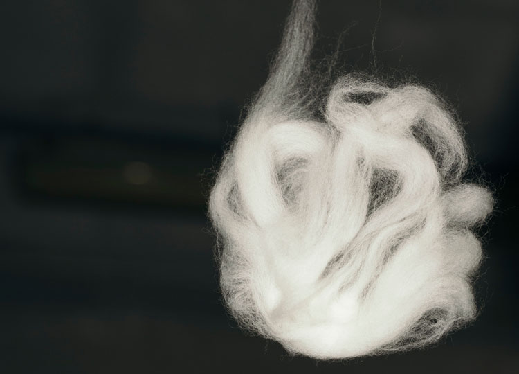 Feine Merino‑Air Fasern in weicher, luftiger Struktur – extrafeine, mulesingfreie Merinowolle als Grundlage moderner Premium‑Strickmode.