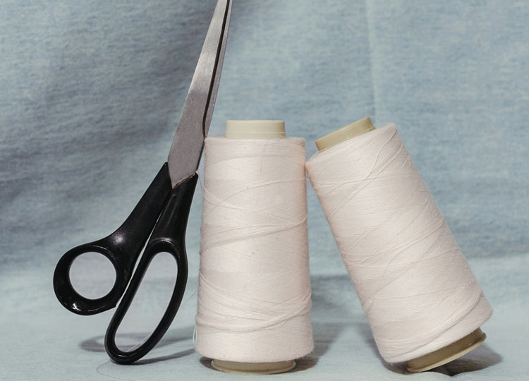 Feine Spulen aus Cotton‑und‑Linen‑Garn, ruhig und hochwertig inszeniert – natürliche Materialien für moderne Premium‑Sommerlooks.