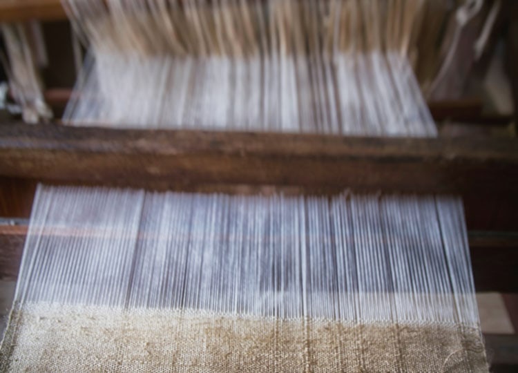 Linenfasern im Webprozess, natürlich strukturiert und hochwertig verarbeitet – Basis feiner, luftiger Premium‑Sommerstoffe.