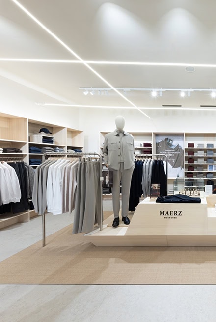 Verkaufsfläche im MAERZ Muenchen Store mit Strickkollektion, Präsentationstisch und Schaufensterfigur.